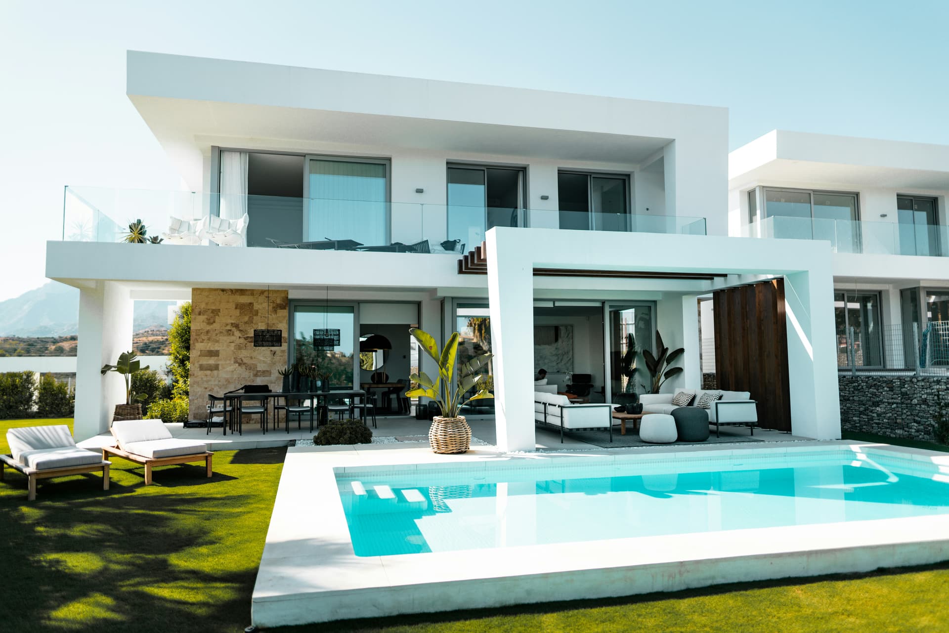 A contemporary white villa with a private pool and open living pavilion