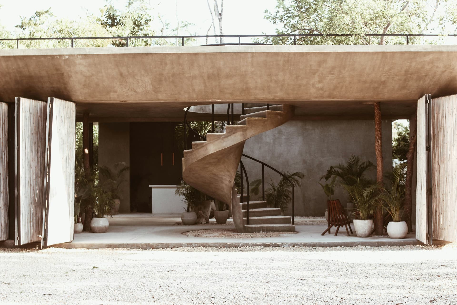 A sculptural concrete stair inside a contemporary tropical building
